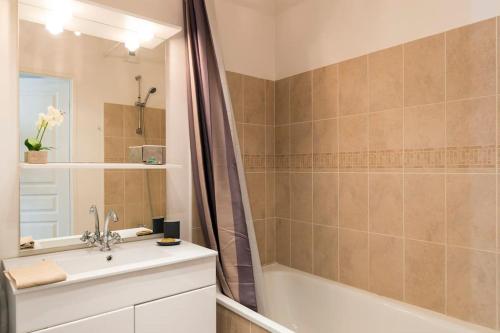 a bathroom with a tub and a sink and a shower at Petit Erdre - 2 chambres- gd appt ensoleillé- accès PMR in Nantes