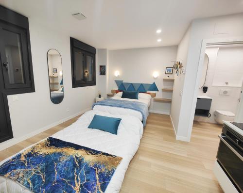 a bedroom with two beds with blue pillows at Apartamentos Centro Oviedo Caveda in Oviedo
