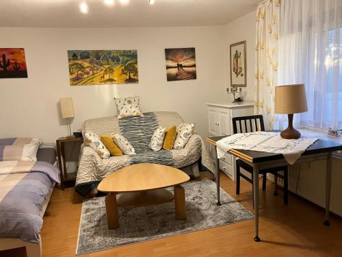 una sala de estar con un sofá y una mesa en Ferienwohnung im Grünen EG mit Terrasse, en Herdecke