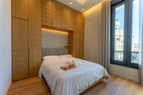 a bedroom with a bed with a tray of food on it at Tendillas Room in Córdoba