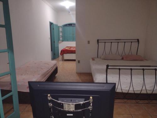 Cette chambre comprend 2 lits et une télévision. dans l'établissement Cada De Hospedagem Vida No Paraíso, à Angra dos Reis