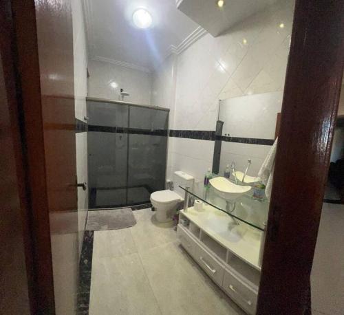 a bathroom with a sink and a toilet and a mirror at Casa Aconchegante in Belo Horizonte