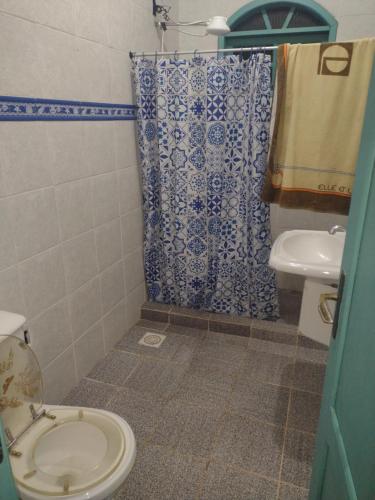 baño con cortina de ducha azul y blanco y aseo en Cada De Hospedagem Vida No Paraíso en Angra dos Reis