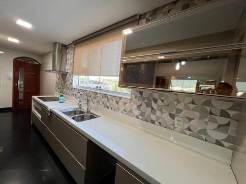 a kitchen with a sink and a counter top at Casa Aconchegante in Belo Horizonte