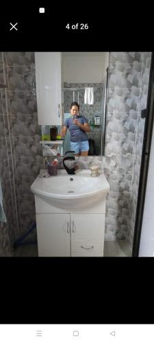 een man die een foto van zichzelf neemt in een badkamerspiegel bij Yang guest house/private room in Dauis