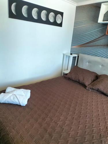 - une chambre avec un grand lit et une couverture brune dans l'établissement Habitaciones Barrancas, à San Antonio