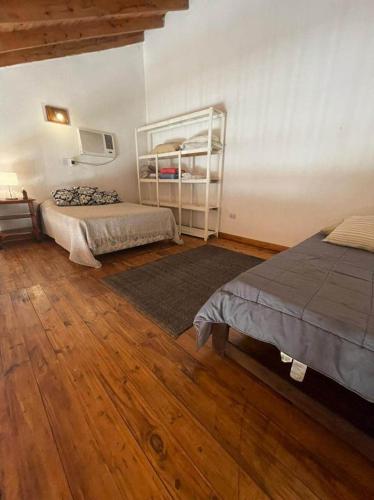 um quarto com 2 camas e piso em madeira em Hospedaje en zona centro! em Esquina