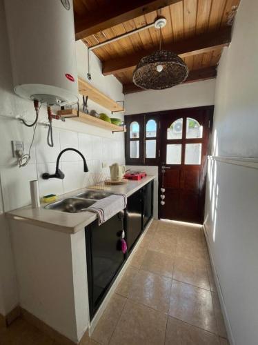 uma cozinha com um lavatório e um fogão forno superior em Hospedaje en zona centro! em Esquina