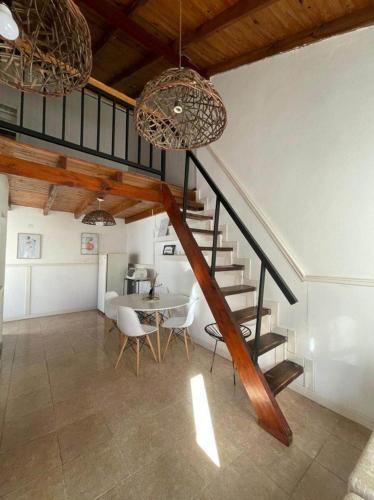 a room with a staircase and a table with chairs at Hospedaje en zona centro! in Esquina