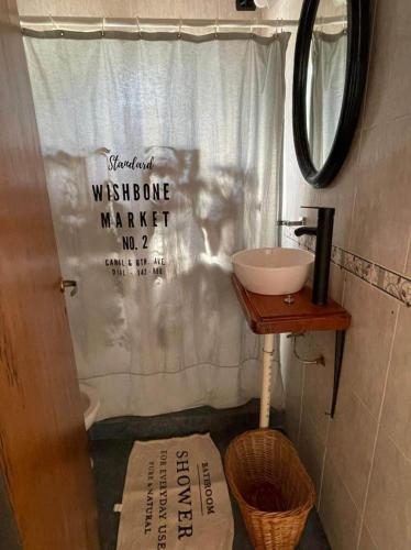 a bathroom with a sink and a white shower curtain at Hospedaje en zona centro! in Esquina