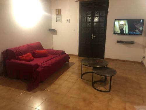 a living room with a red couch and a table at KAN'DLO in Le Morne Rouge