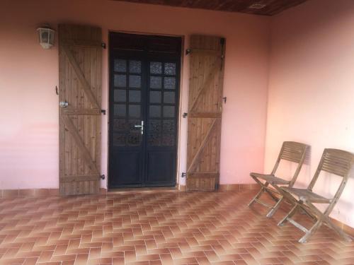 two chairs sitting in front of a door at KAN'DLO in Le Morne Rouge