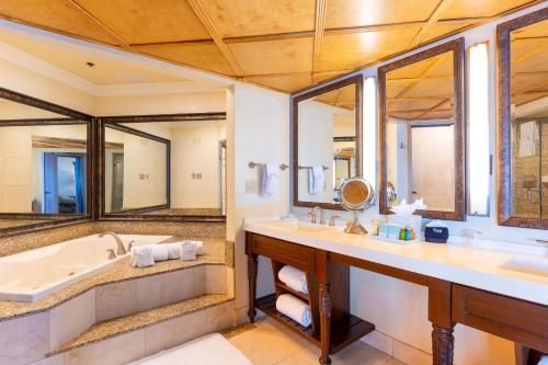 ein Badezimmer mit zwei Waschbecken, einer Badewanne und Spiegeln in der Unterkunft Pacific Terrace Hotel in San Diego