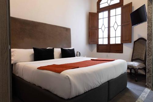 1 dormitorio con 1 cama grande y ventana en Artea Hotel Boutique, en Guadalajara