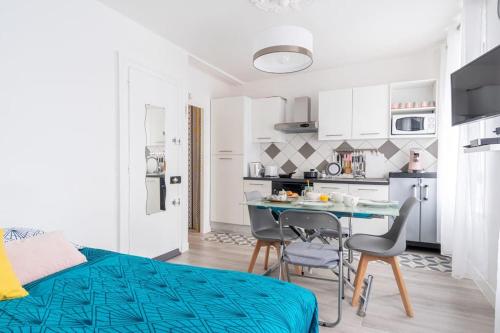 une chambre avec un lit, une table et des chaises dans l'établissement Le Petit Cocon - 150m de la Plage - 3 pers, à Étretat