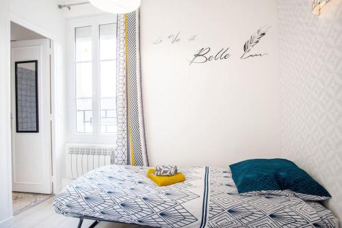 une chambre avec un lit et un panneau sur le mur dans l'établissement Le Petit Cocon - 150m de la Plage - 3 pers, à Étretat