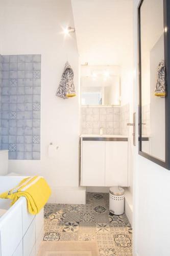 une salle de bain blanche avec un lavabo et un miroir dans l'établissement Le Petit Cocon - 150m de la Plage - 3 pers, à Étretat