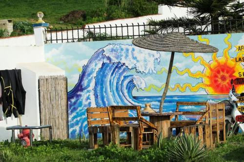 a wall with an umbrella and a table and chairs at Surf house apartment in Oualidia