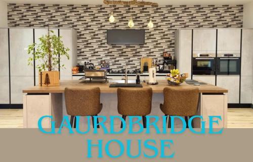 een keuken met een groot keukeneiland met stoelen bij Guardbridge House, Spacious Inside and Out, Golfer and Groups Favourite, 5 Beds, 2 Superking en suites, 3 Kingsize rooms, Bathroom & WC, Fully Equipped Kitchen, FREE Parking for 4 Large Vehicles, 10 mins to St Andrews, 15 mins to Dundee, BBQ in Balmullo
