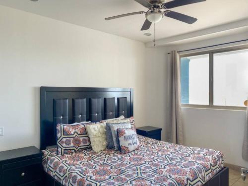 een slaapkamer met een bed en een plafondventilator bij Unwind in a Modern Condo with Stunning View in Puerto Peñasco