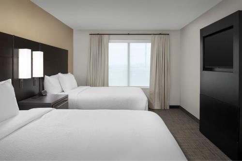 a hotel room with two beds and a flat screen tv at Residence Inn by Marriott Dallas Grand Prairie in Grand Prairie