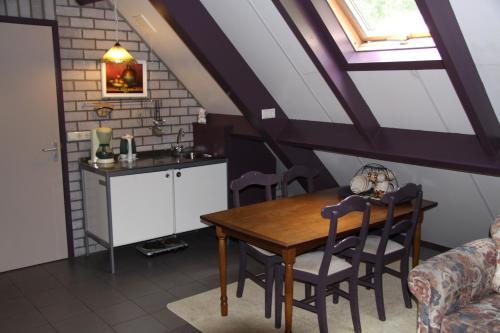 een keuken en eetkamer met een tafel en stoelen bij Appartement Hoeve Polsdonk in Oirschot