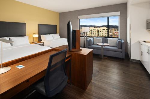 a hotel room with a bed and a desk and a couch at Element Bozeman in Bozeman