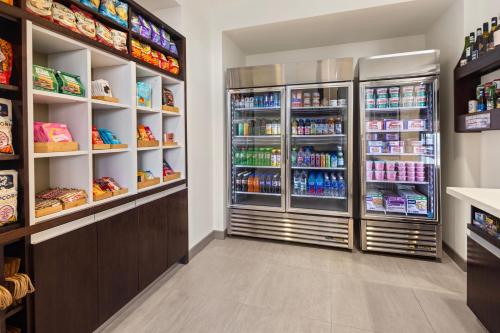 a store aisle with a refrigerator filled with drinks at Element Bozeman in Bozeman