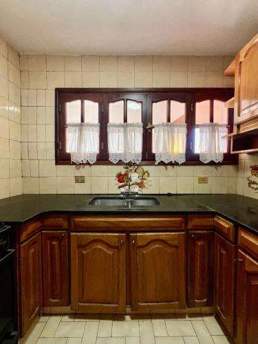 a kitchen with wooden cabinets and a sink at Casa andina in Esquel