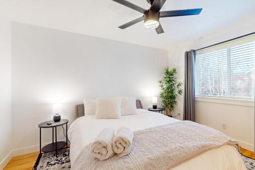 a bedroom with a bed with white sheets and a ceiling fan at Poree Domaine Bend in Bend