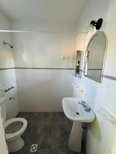 a bathroom with a toilet and a sink and a mirror at Casa andina in Esquel