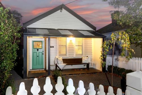 a tiny house with a green door and a bench at The Hidden Door Bowral Cottage - The Love of Bowral in Bowral