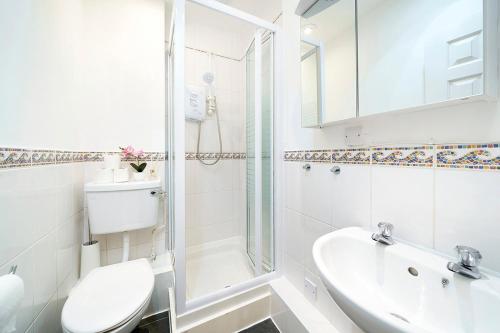 ein Bad mit einem WC, einem Waschbecken und einer Dusche in der Unterkunft Brewer Street Central Apartments in London