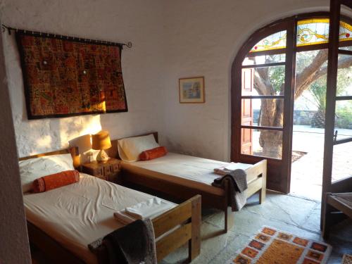 1 dormitorio con 2 camas y ventana en Olive Grove House, en Argalasti