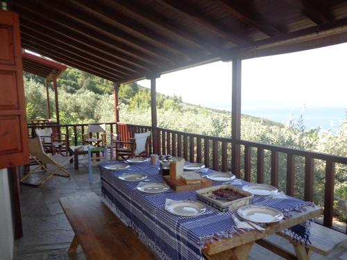 a table with plates of food on a balcony at Olive Grove House in Argalasti