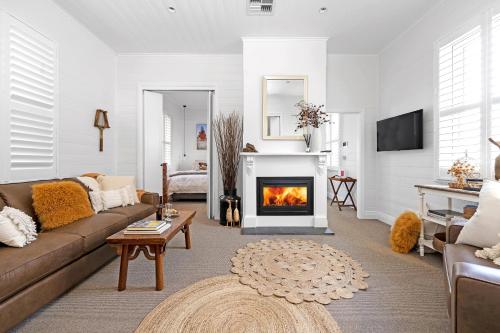 a living room with a couch and a fireplace at The Hidden Door Bowral Cottage - The Love of Bowral in Bowral
