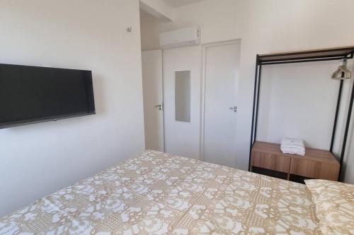 a bedroom with a bed and a flat screen tv at Apto completo com 02 quartos climatizados, estacionamento e portaria 24 horas, próximo ao Aeroporto! in Juazeiro do Norte