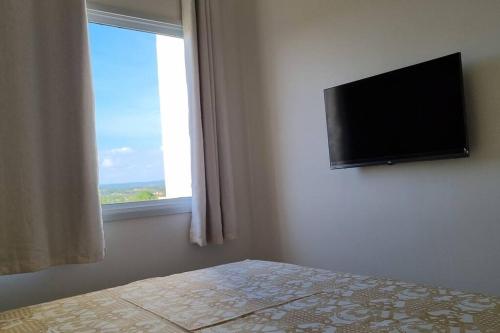 a bedroom with a flat screen tv and a bed at Apto completo com 02 quartos climatizados, estacionamento e portaria 24 horas, próximo ao Aeroporto! in Juazeiro do Norte