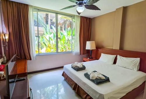 a bedroom with a bed with a window and a ceiling fan at Piman Garden Boutique Hotel in Khon Kaen