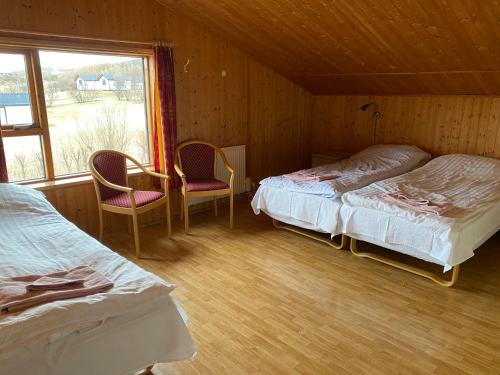 a bedroom with two beds and a table and two chairs at Bakkaflöt Guesthouse in Varmahlid