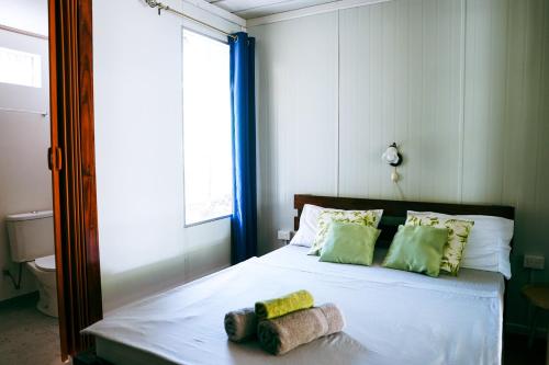 a bedroom with a bed with two towels on it at House in the palm forest in Carrillo