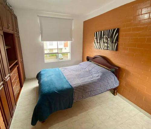 a bedroom with a bed and a brick wall at Encantadora Casa en Eje Cafetero in Dosquebradas