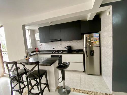 a kitchen with a refrigerator and a table and chairs at Encantadora Casa en Eje Cafetero in Dosquebradas