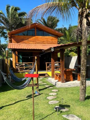 een resort met een hangmat en een huis bij Chalé de Madeira, a 60m do mar em condomínio in Vera Cruz de Itaparica
