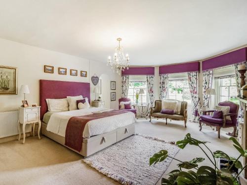 a bedroom with a king sized bed and purple accents at Llwynhelig House - Uk46395 in Cowbridge