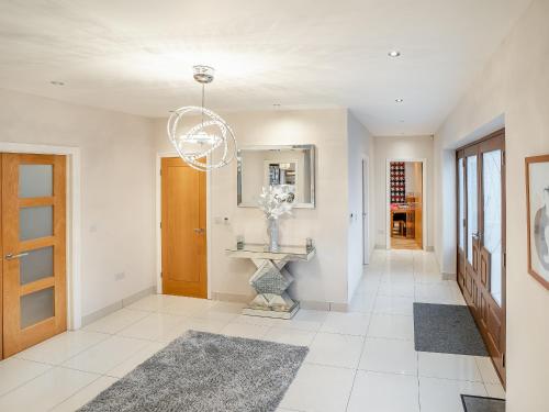 a hallway with a table with a vase of flowers at Wernddu Fechan House - Uk42932 in Neath