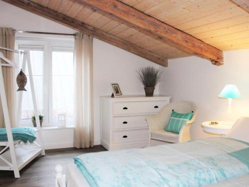 a bedroom with a bed and a dresser and a window at Tranquil holiday home with garden in Kronsgaard