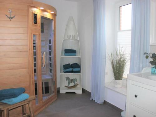 a bathroom with a shower and a sink and a mirror at Tranquil holiday home with garden in Kronsgaard