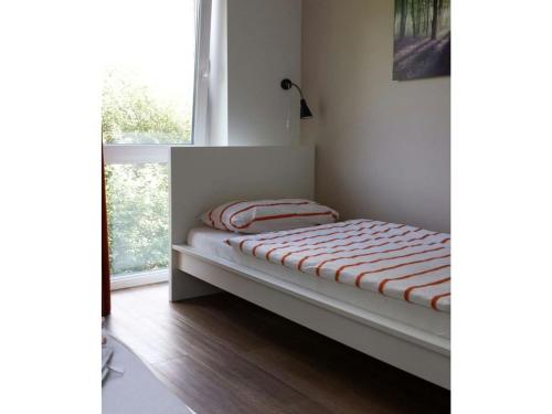 Cama pequeña en habitación con ventana en Apartment bare with ebike rental, en Oldenburg