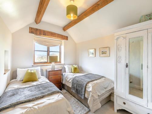 sypialnia z 2 łóżkami i oknem w obiekcie Hillcrest Cottage w mieście Stroud